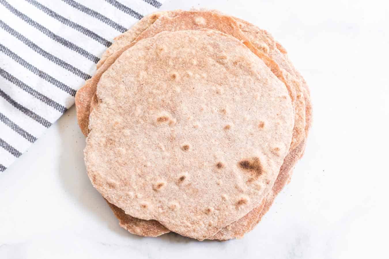 Hearty and healthy, whole wheat tortillas are beyond simple to make and go great with bold flavored wraps, tacos, and gyros!