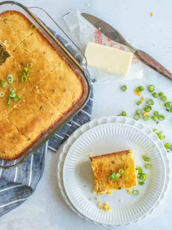 top view of the baking dish with cornbread and one square of cornbread on a white plate.