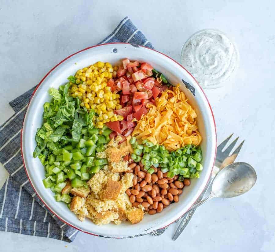 top view of the cornbread salad recipe ingredients in a white bowl.