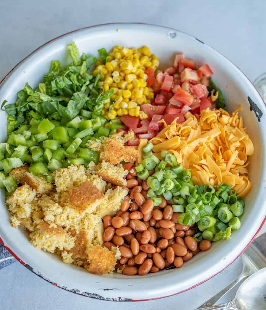 close up of the salad not mixed together, you can see the cornbread, peppers, tomato, cheese and more