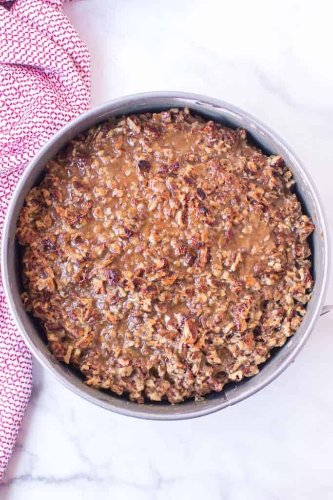 oatmeal cake with sticky nut icing in a cheesecake tin top view