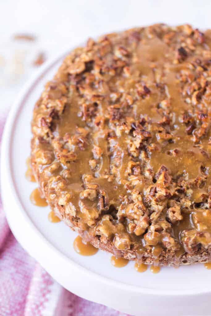 top view - oatmeal cake with sticky nut icing on top of a white cake stand