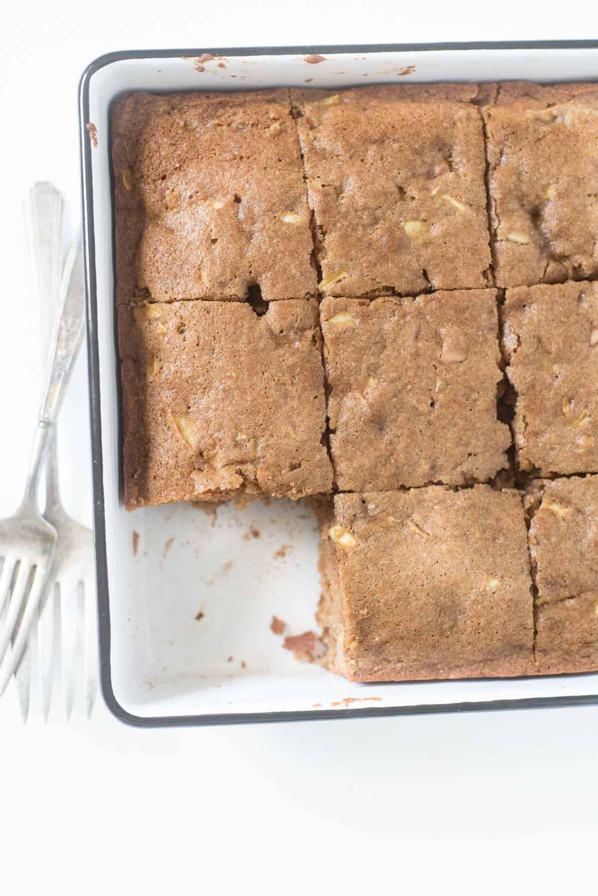 A square baking dish of easy apple cake cut into squares