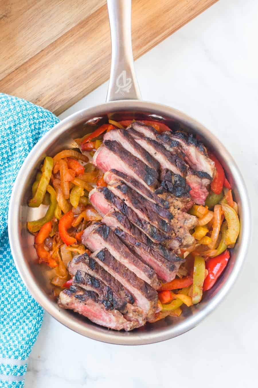 top view of a pot with flank steak and bell peppers