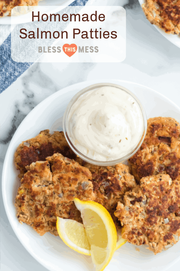 A white plate features golden-brown salmon patties and lemon wedges, accompanied by a small bowl of creamy sauce. The text above reads Homemade Old-Fashioned Salmon Patties on a translucent background with Bless This Mess below it.