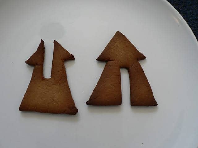 Baked gingerbread pieces in the shape of trees with notches to fit together