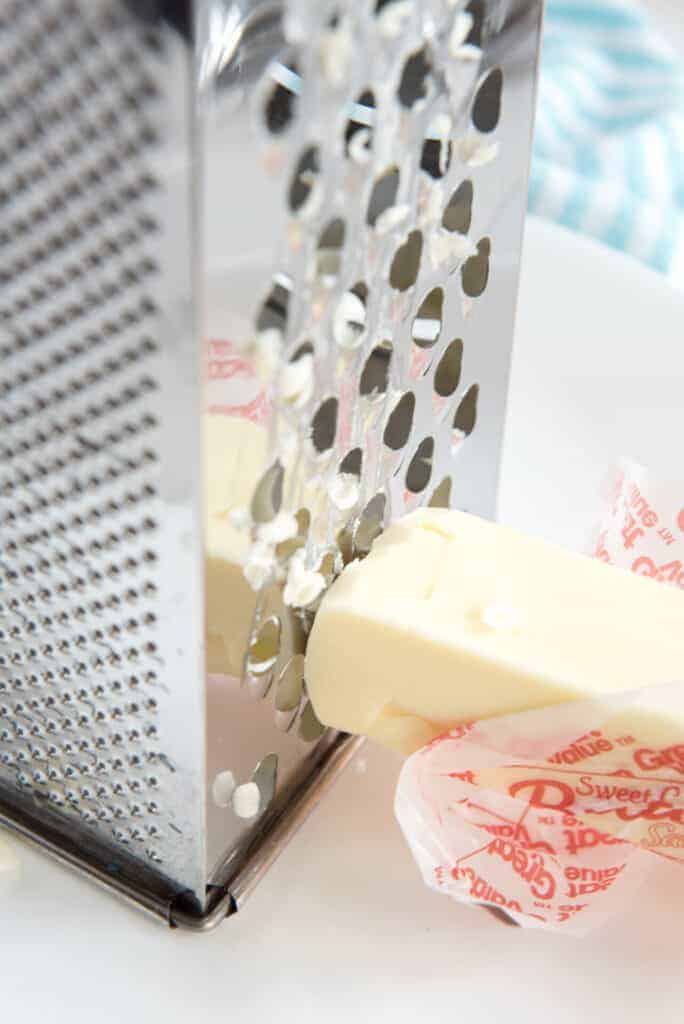 grading a hard butter stick with a cheese grater