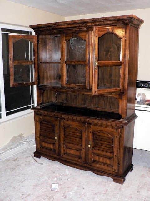 brown furniture hutch with glass doors on top and closed doors on bottom.