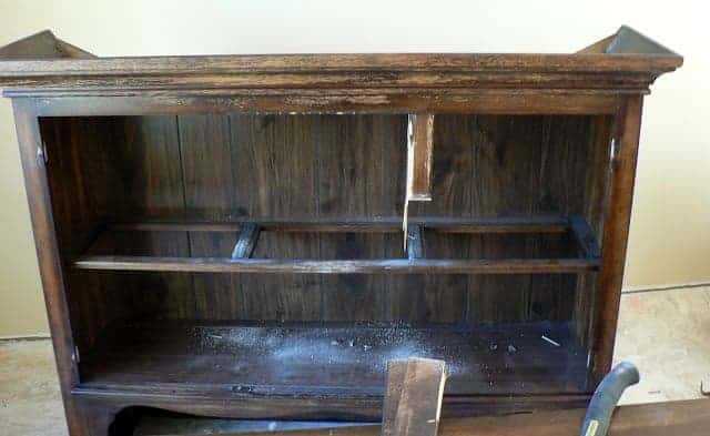 brown piece of furniture with doors and hinges removed being prepared for painting.