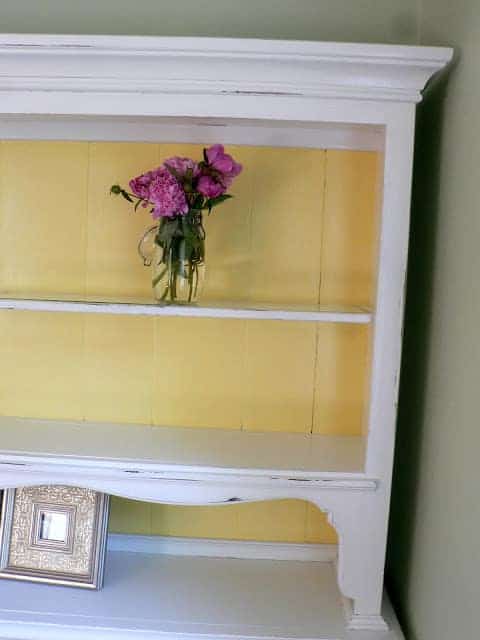 top part of furniture hutch painted white with yellow on back.