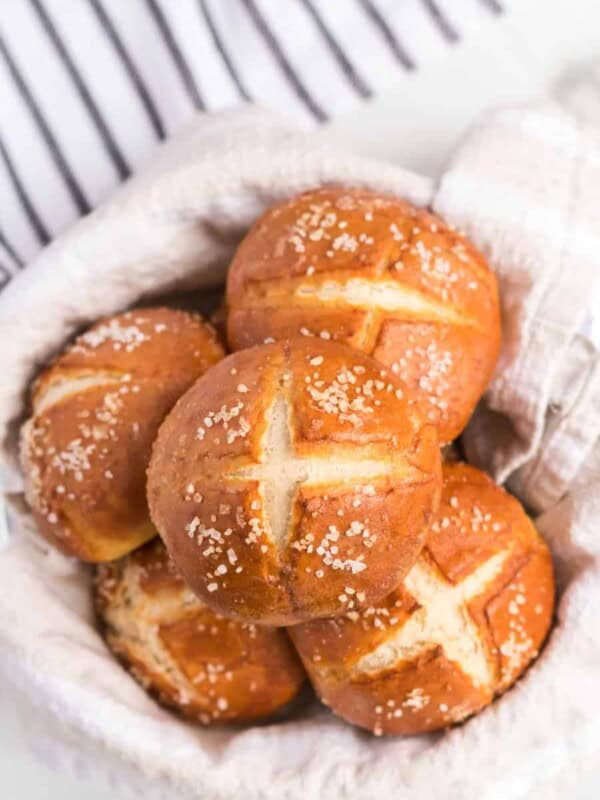 an overhead shot of some pretzel rolls in a linen lined bowl.