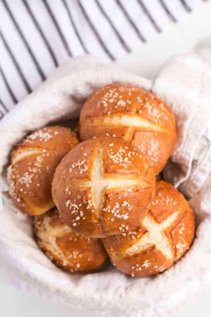an overhead shot of some pretzel rolls in a linen lined bowl.
