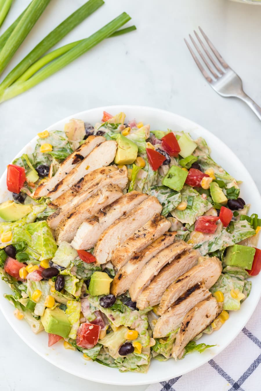 Barbecue ranch chicken salad is the most flavorful salad you'll ever eat, complete with a smoky and sweet dressing, grilled chicken, avocado, tomato, corn, romaine, and a whole lot of other vibrant veggies.