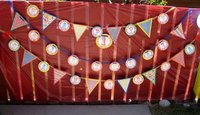 Circus-themed happy birthday flag banner in front of a red backdrop