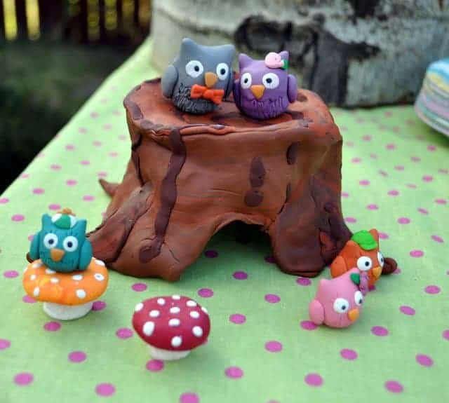Owl-themed party decorations with owls on a log 