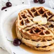 sweet cherry waffles with butter on top on a white plate