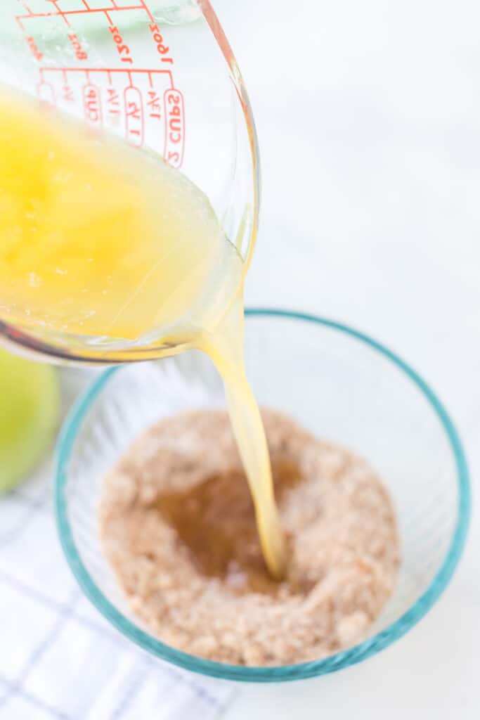 apple crumble topping with butter being poured into it