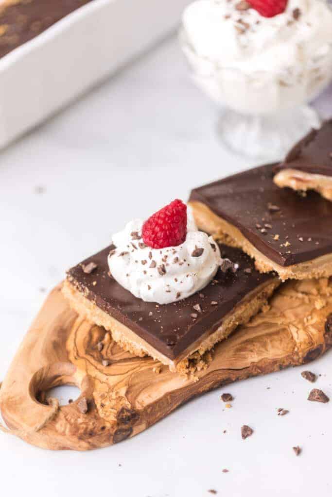 chocolate caramel tart with whipped cream and a raspberry on top