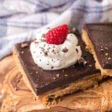 chocolate caramel tart with whipped cream and a raspberry on top