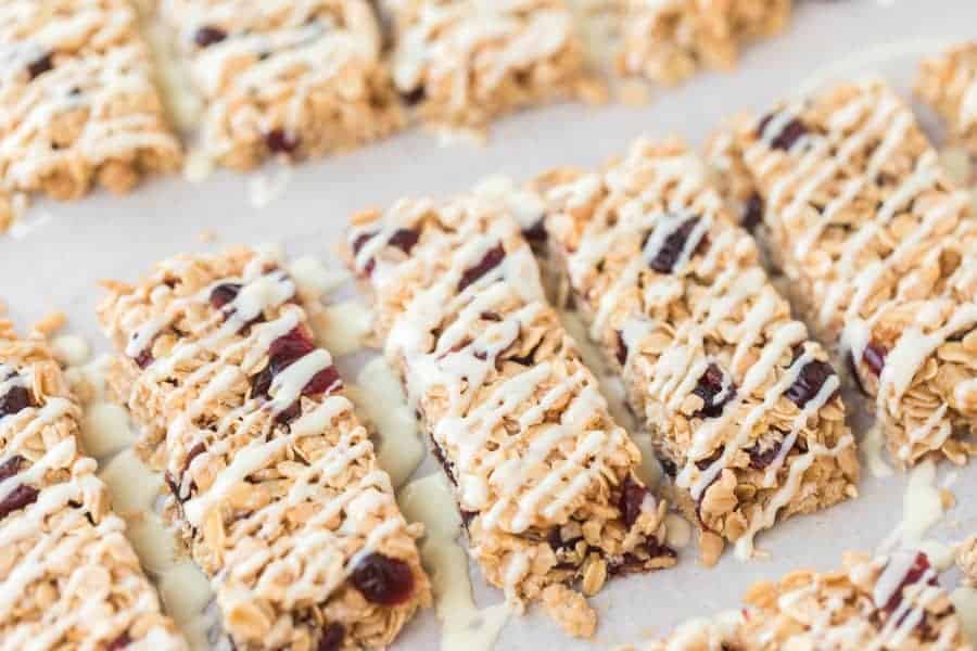 White chocolate and cranberry granola bars are the perfect grab-and-go snack, and they are so simple to make at the beginning of the week to have on the go all week long. I love a granola bar because it's packed with nutrients and vitamins, and these ones taste indulgent even though they're full of nutritious ingredients! #granolabars #homemadegranolabars #cranberrywhitechocolate #proteinbars #snack #homemadesnack #snackrecipes