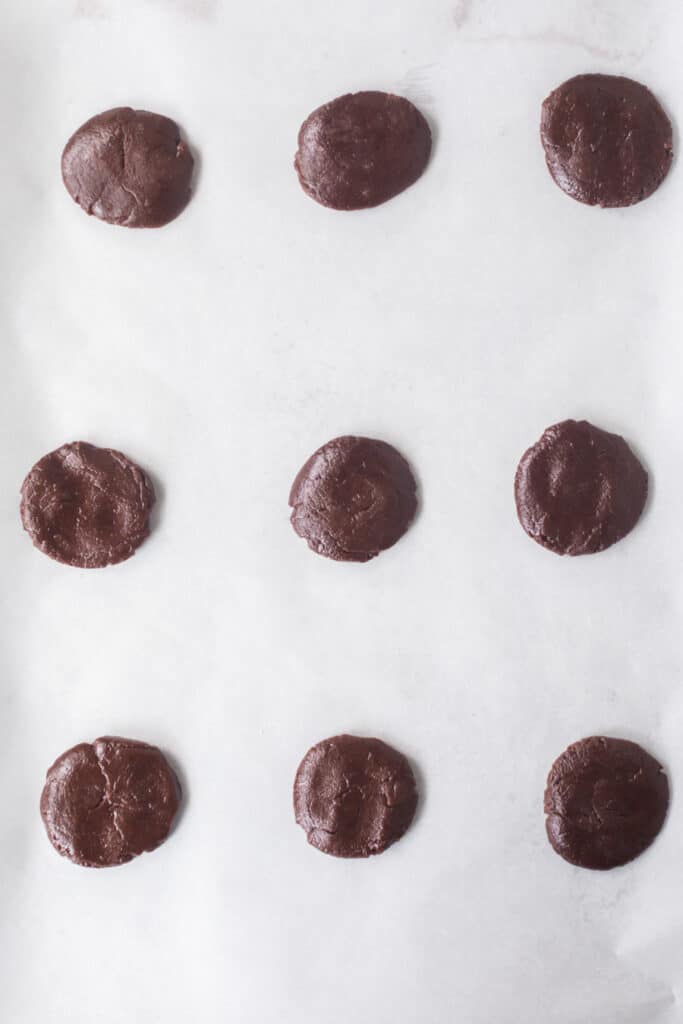 the top of homemade oreos on parchment on a baking sheet, raw