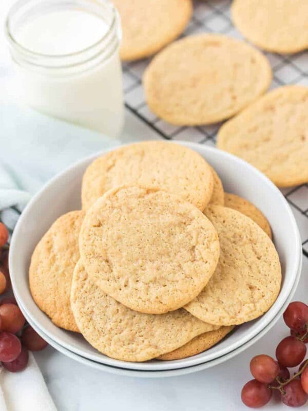 a bowl and a cooling rack of thin golden cookies