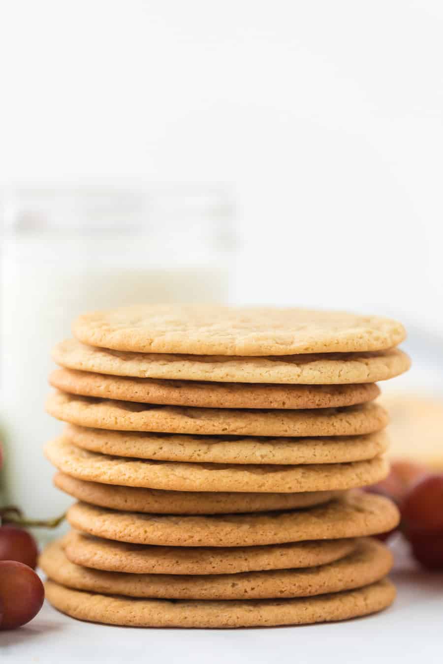 A stack of baked cookies with purple grapes on either side.