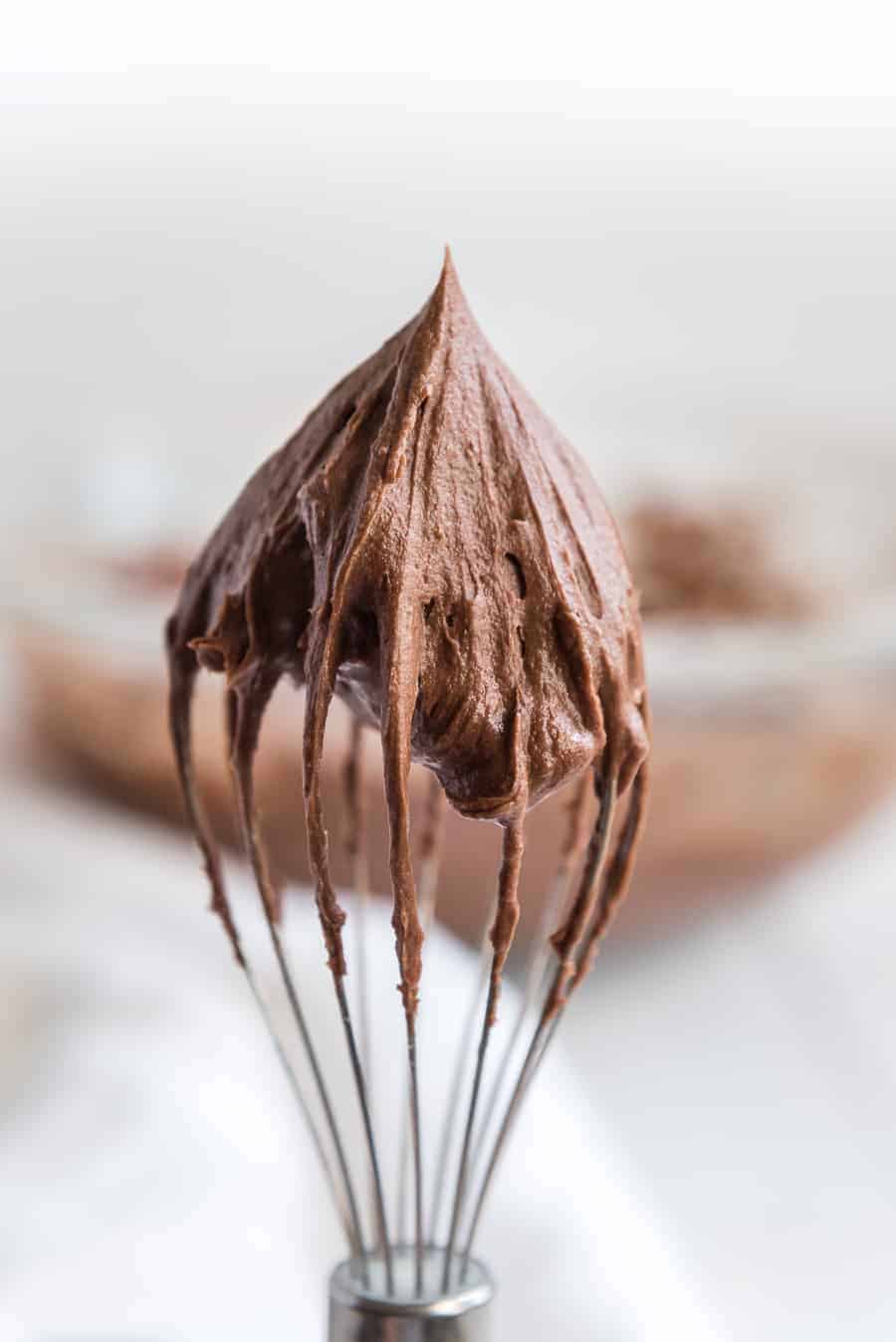 a whisk with chocolate frosting on it.