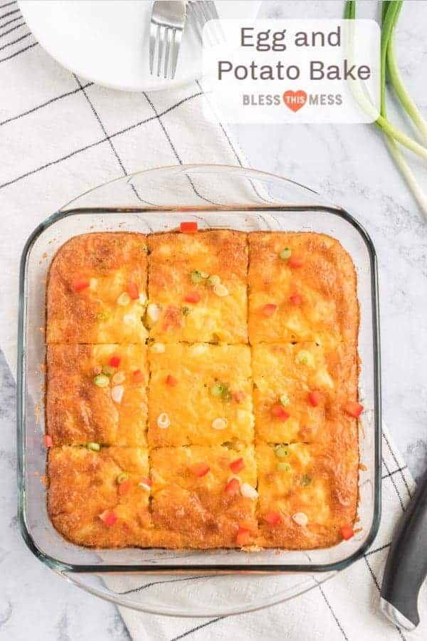 Top view of a square baking dish of egg and potato bake garnished with minced red peppers and scallions