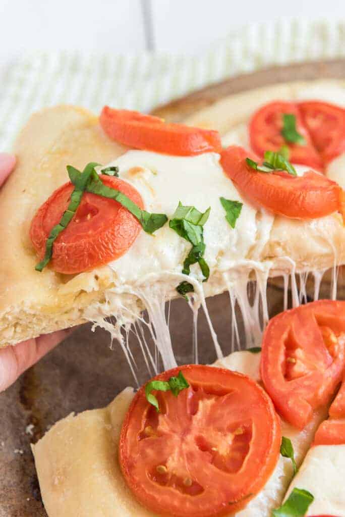 pov pulling apart a classic margarita pizza