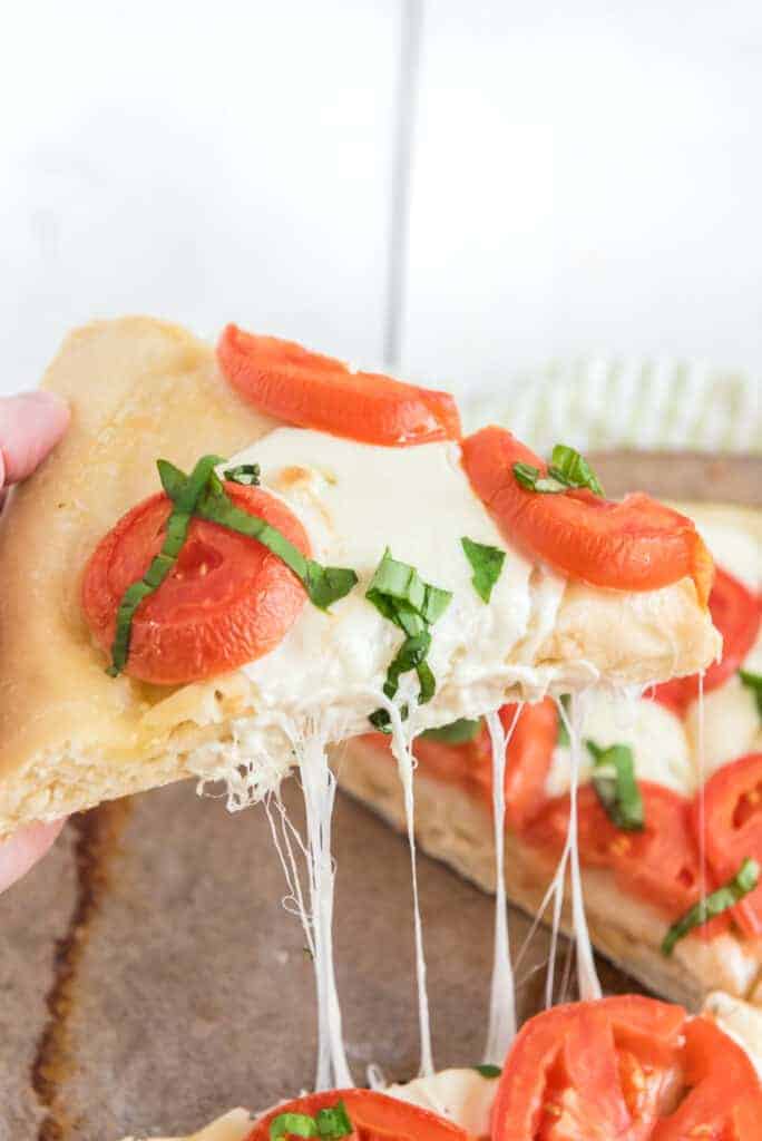 pov pulling apart a classic margarita pizza