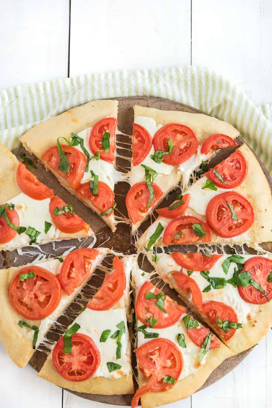 This easy margherita pizza recipe is made of a simple homemade pizza dough with fresh tomato, mozzarella, and basil for a fun and casual meal you can make at home. It's the ideal meal for a busy weeknight or a low-key movie night on the weekend, and it's beyond simple to make from scratch with minimal ingredients. #pizza #margheritapizza #margheritapizzarecipe #pizzarecipe #homemadepizza #homemadepizzadough #pizzadoughrecipe