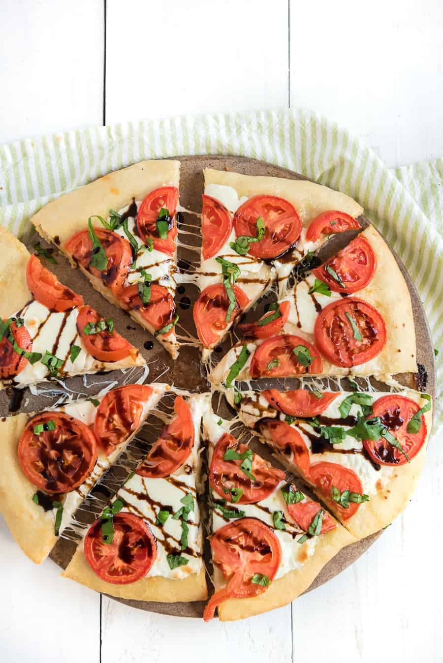 This easy margherita pizza recipe is made of a simple homemade pizza dough with fresh tomato, mozzarella, and basil for a fun and casual meal you can make at home. It's the ideal meal for a busy weeknight or a low-key movie night on the weekend, and it's beyond simple to make from scratch with minimal ingredients. #pizza #margheritapizza #margheritapizzarecipe #pizzarecipe #homemadepizza #homemadepizzadough #pizzadoughrecipe