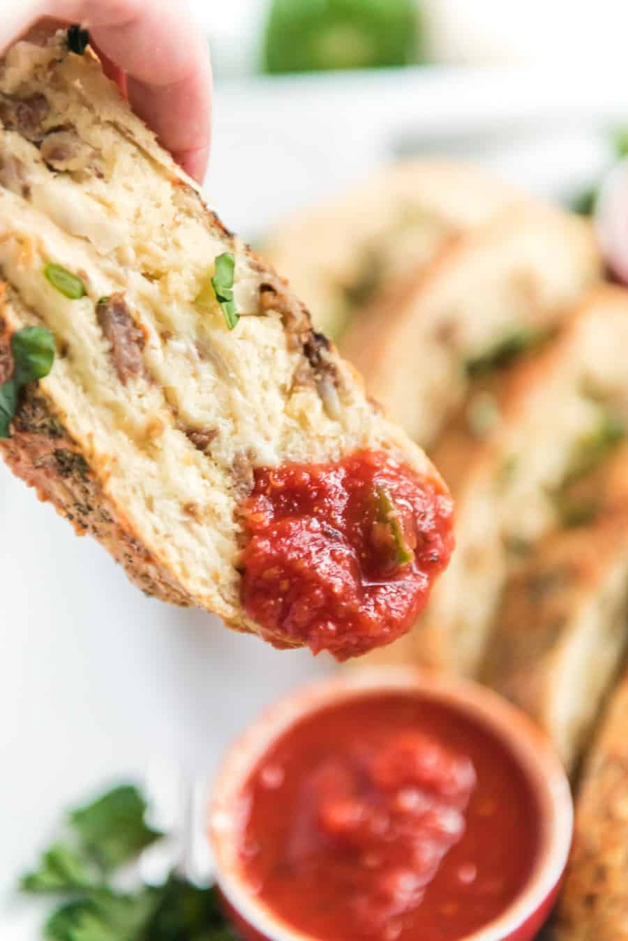 Cheesy Sausage and Pepper Stromboli made with homemade pizza crust, lots of sausage and cheese, and all rolled up into dippable pizza-like slices the whole family will love.