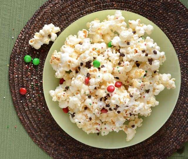 popcorn in a large green bowl on a brown placemat