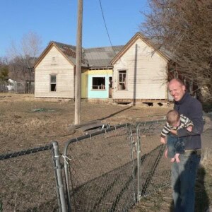dad and baby looking at the old shanty house