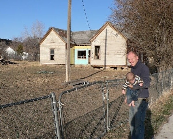 dad and baby looking at the old shanty house