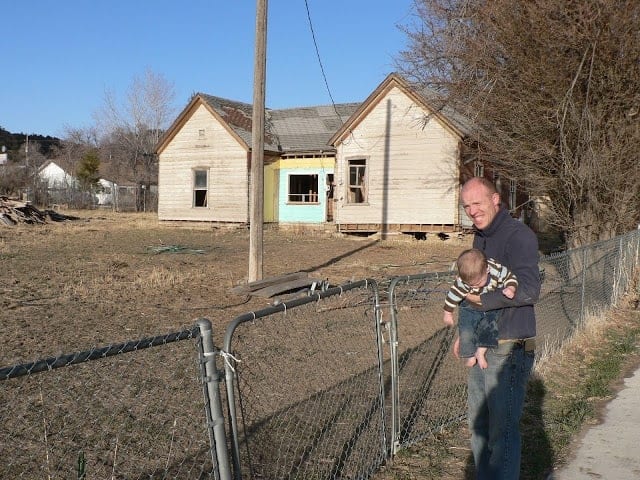 dad and baby looking at the old shanty house