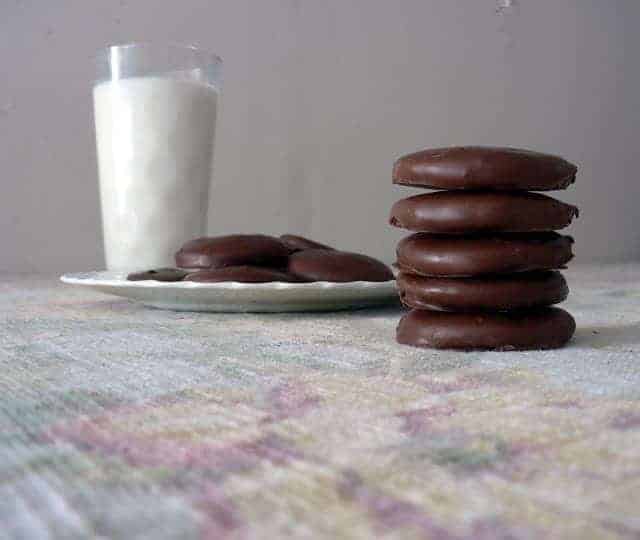 a stack of thin mints and thin mints on a plate next to a glass of milk