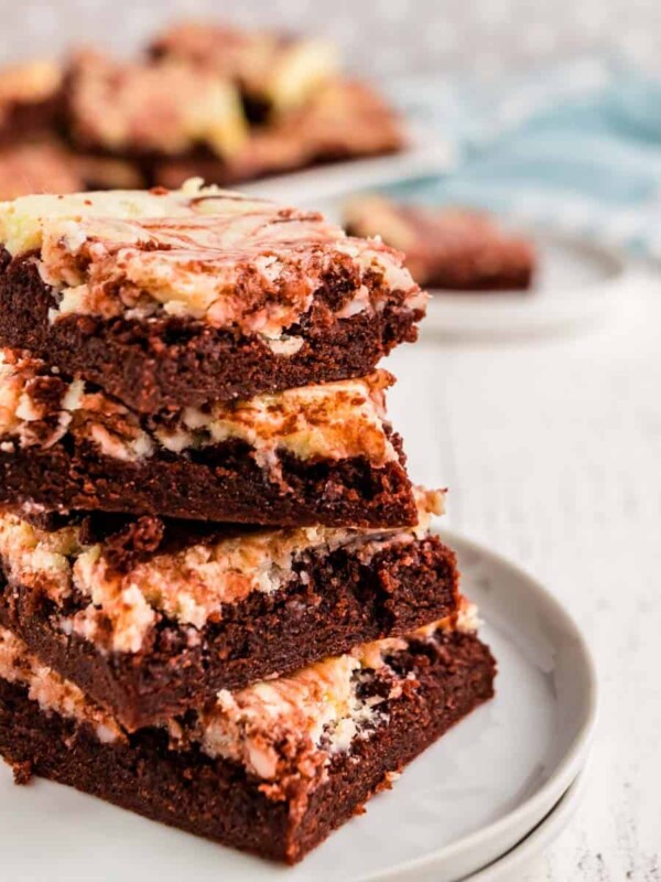 red velvet cheesecake brownies stacked on top of each other on a plate