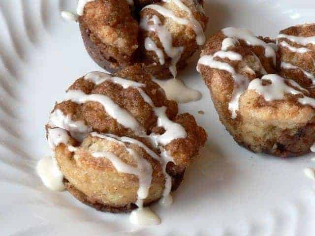 a close up of Monkey Bread Muffins with icing on a white plate
