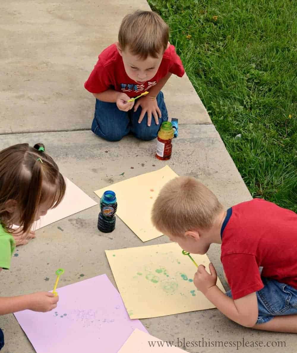 kids blowing bubbles onto paper