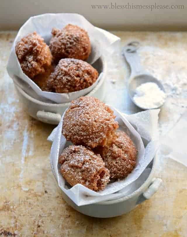 donut holes wrapped in wax paper in a cup