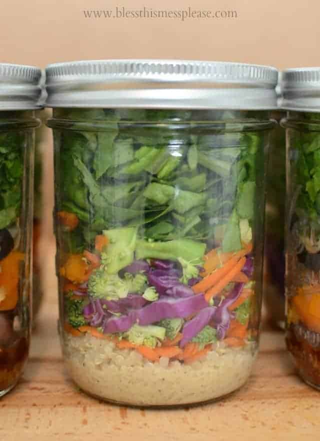 a closeup shot of a salad showing its layers of red cabbage, orange carrots, and green spinach