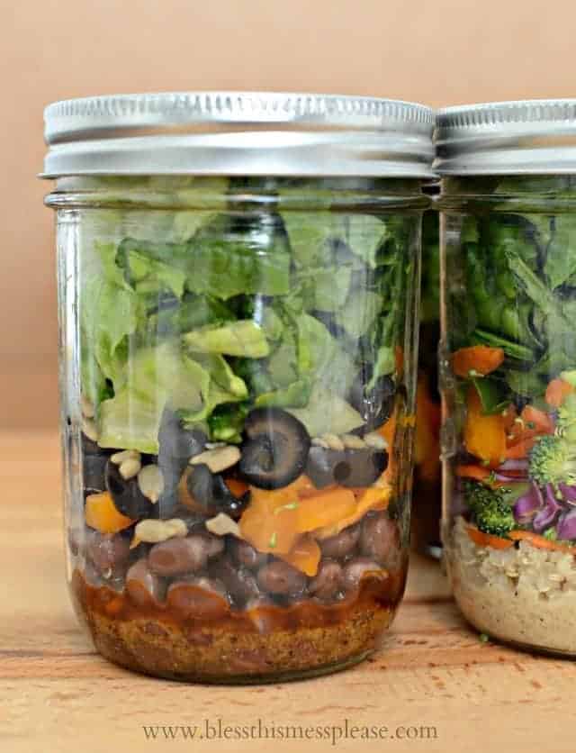 A closeup shot of a salad in a jar showing its colorful layers of beans, peppers, and lettuce