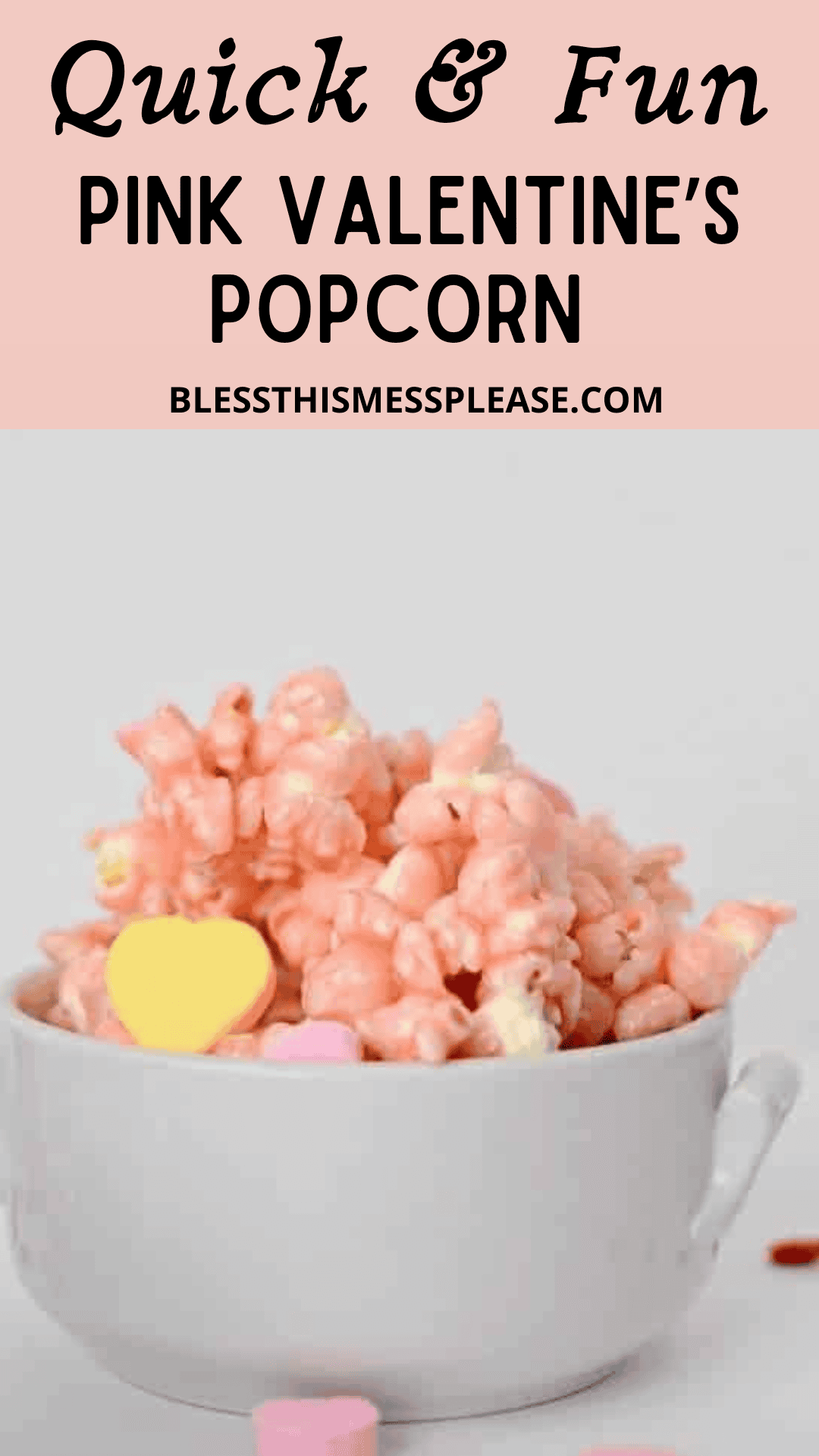 A white bowl filled with pink popcorn and colorful heart-shaped candies, set against a plain background. Text above reads: &ldquo;Quick & Fun Pink Valentine Popcorn Treat&rdquo; with a website URL underneath.