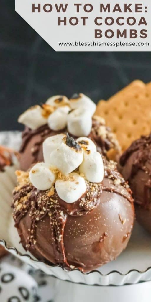 side view of three Hot chocolate bombs with marshmallows and gram crackers