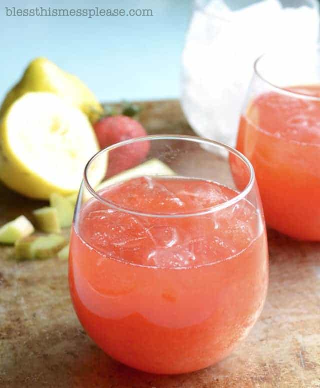 Strawberry Rhubarb Lemonade in a glass with a lemon to the side