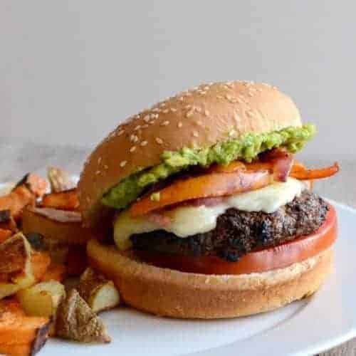fajita seasoned burger with veggies on top and an avocado spread