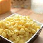 A square serving dish of mac and cheese with shells and elbow macaroni